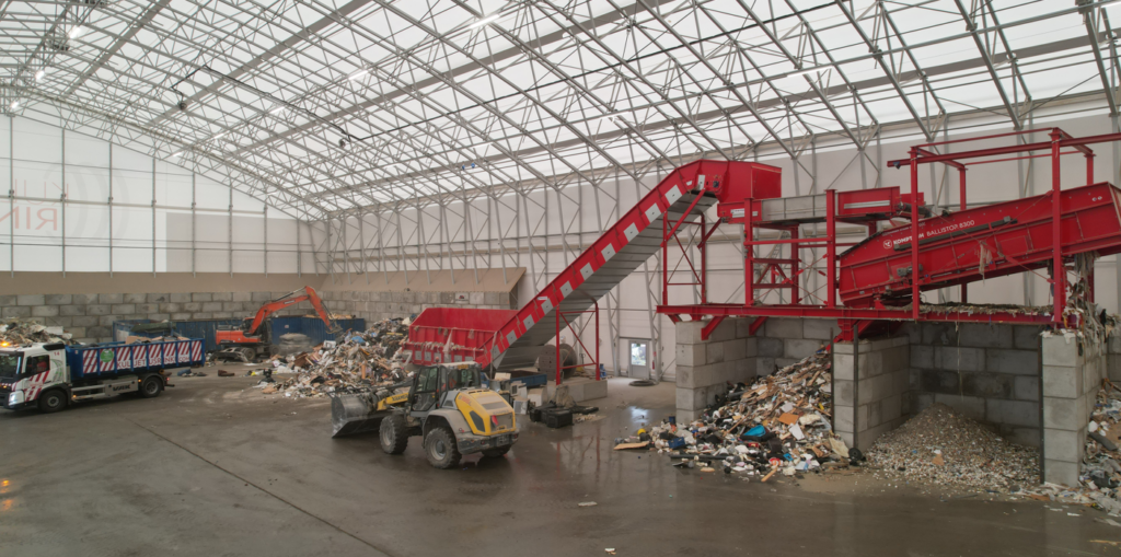 Sekalaista jätevirtaa siirretään käsittelylinjastolle traktorin, kaivinkoneen ja kuormaauton avulla.